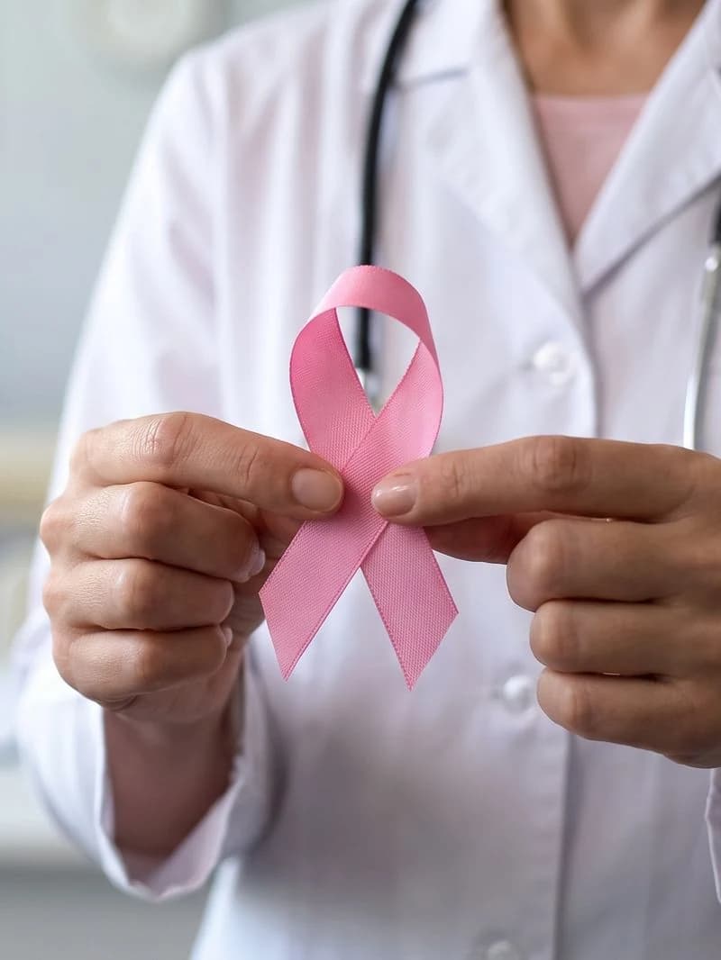 Doctor holding a pink awareness ribbon